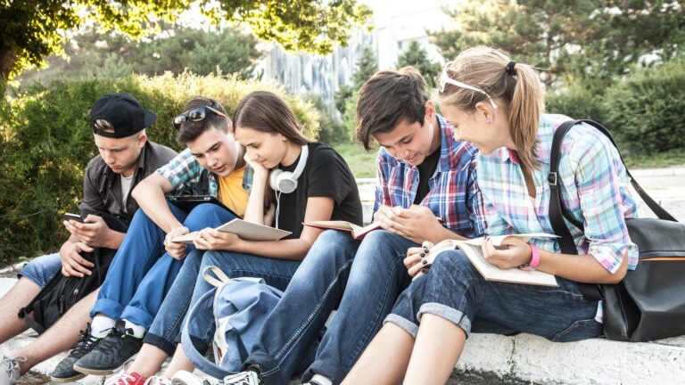 Tieners/leerlingen op een rij buiten tijdens de pauze van hun schooldag.